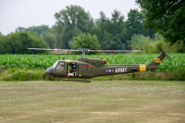 Twee modelhelikopters in legerkleuren op het veld