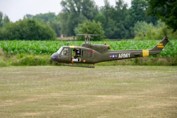 Twee Huey-modelhelikopters voor de bomenrij